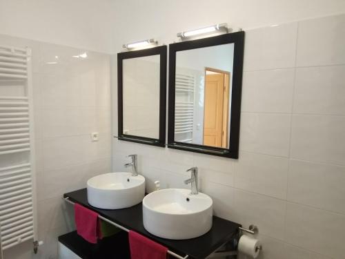 a bathroom with two sinks and two mirrors at Studio indépendant 40m² avec jardin privé in Hauteville-Lompnes