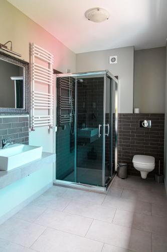 a bathroom with a glass shower and a toilet at Villa Orient in Iława
