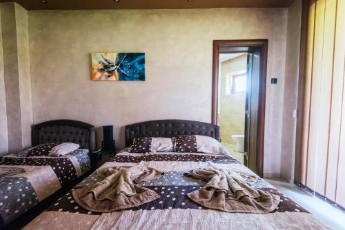 dos camas sentadas una al lado de la otra en un dormitorio en ATOS Srebrno jezero - Villa and Restaurant, en Veliko Gradiste