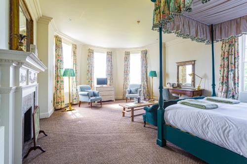 a bedroom with a canopy bed and a fireplace at The Talbot, Malton, North Yorkshire in Malton