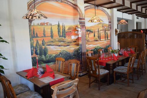 a dining room with tables and chairs and a painting at Hotel Carola in Sch&ouml;nheide
