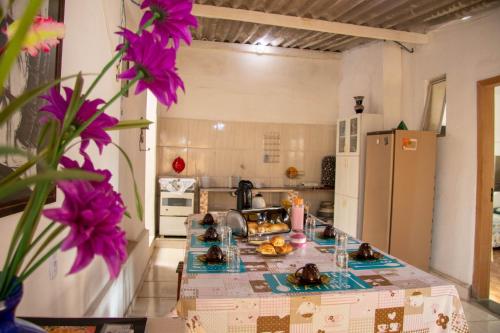 a kitchen with a counter with purple flowers on it at Casa do Juá in Lavras