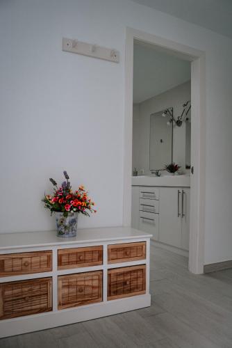 a bathroom with a counter with a vase of flowers on it at DanySer Suites Vacacionales in Agulo