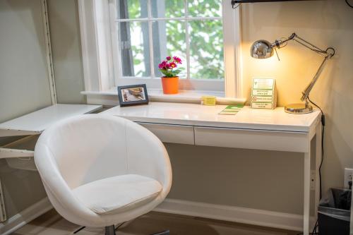 a white desk with a white chair and a lamp at The Georgetown House Inn in Washington