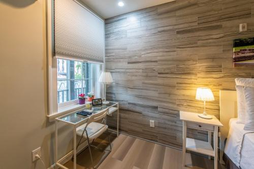 a bedroom with a wooden wall with a desk and a bed at The Georgetown House Inn in Washington