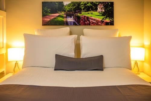 a bedroom with a white bed with two lamps at The Georgetown House Inn in Washington