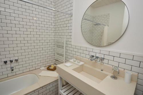 Baño blanco con lavabo y espejo en Hosteria El Puma en El Chalten