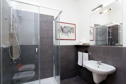 uma casa de banho com uma cabina de duche em vidro e um lavatório. em RomeAsYouLike-Colosseo Experience45 em Roma
