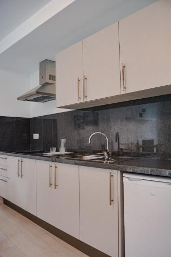 a kitchen with white cabinets and a sink at DanySer Suites Vacacionales in Agulo