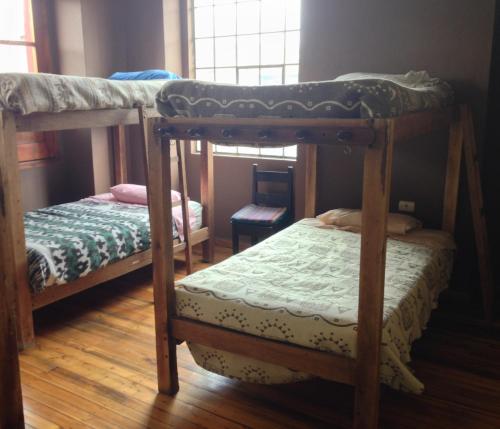 a bedroom with two bunk beds and a window at El Cafecito Hostel Cuenca in Cuenca