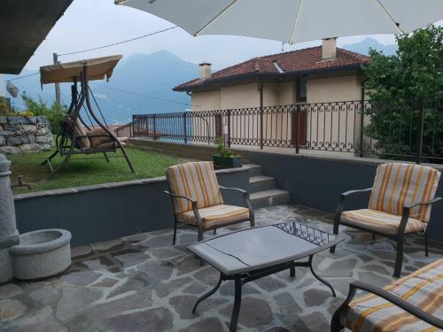 eine Terrasse mit Stühlen, einem Tisch und einem Sonnenschirm in der Unterkunft B&B RUFHOUSE in Lovere