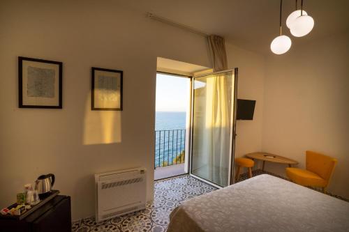 sypialnia z łóżkiem i drzwiami prowadzącymi na balkon w obiekcie Borgo dei Saraceni - Flower Home w Agropoli