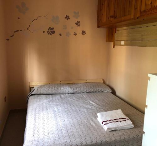 a small bedroom with a bed with a white blanket at Soffio di Maestrale in Ortona