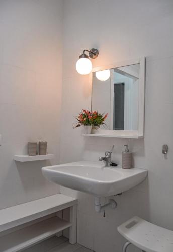 a white bathroom with a sink and a mirror at DanySer Suites Vacacionales in Agulo