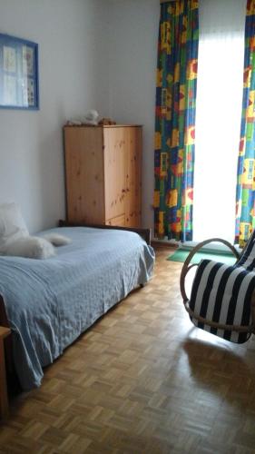 una camera con un letto e una sedia e una finestra di Ferienbauernhof a Lügde