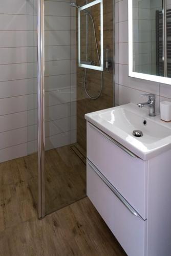 a white bathroom with a shower and a sink at Willa911_Apartamenty in Rzepiska