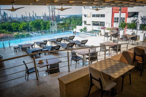un balcone con tavoli, sedie e piscina di Hotel Súper Estrellas a Barrancabermeja