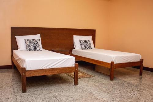 two twin beds in a room withermottermott at Riviera Palace Hotel in Sete Lagoas