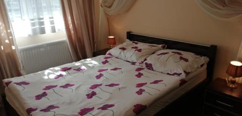 コウォブジェクにあるApartament Oliviaのベッド(紫色の花が飾られた白い掛け布団付)