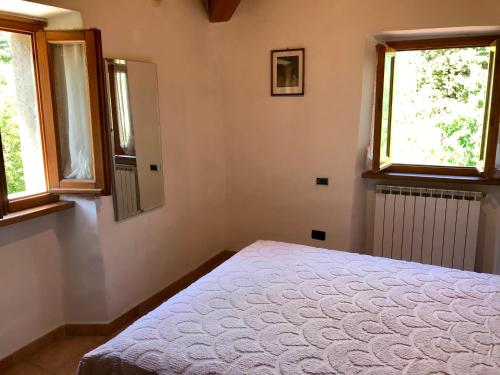 a bedroom with a bed and two windows at THE DORMOUSE - Il Ghiro in Reusa