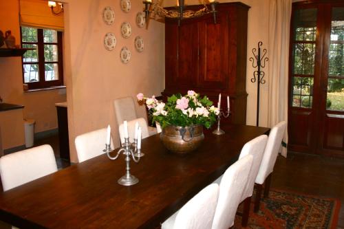 einem Esstisch mit weißen Stühlen und einer Vase aus Blumen in der Unterkunft Tenuta Vitalonga in Ficulle