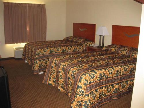 a hotel room with two beds and a window at Heritage Inn in Picayune