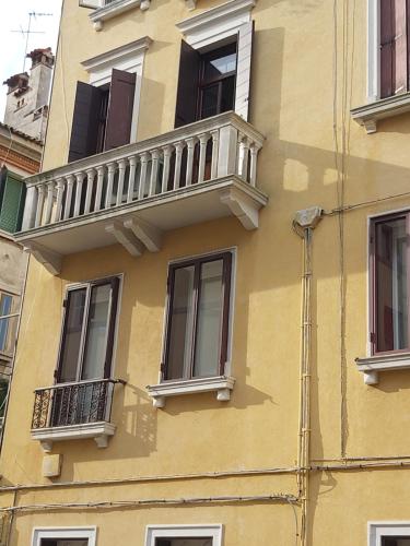a yellow building with windows and a balcony at A Casa di Claudia in Venice