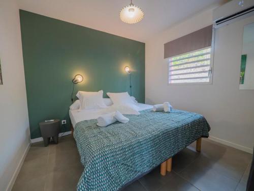 ein Schlafzimmer mit einem Bett mit zwei Handtüchern darauf in der Unterkunft LES VILLAS GLACY in Les Trois-Îlets