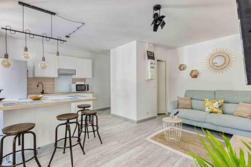 Il dispose d'une cuisine et d'un salon avec un canapé et une table. dans l'établissement Le Vallombrosa T2, à Cannes