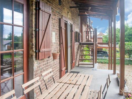 eine Veranda mit einer Holzbank auf einem Backsteingebäude in der Unterkunft Splendid Villa in Vorsen 