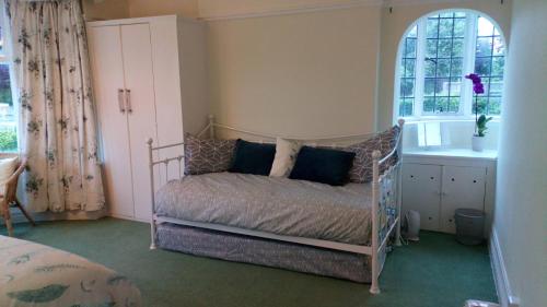a bedroom with a bed and a window at Seawinds Holiday Apartment, dog-friendly in Llandrillo-yn-Rhôs