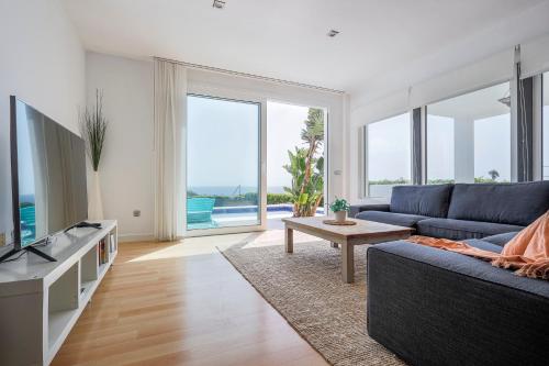 Cádiz punta carnero 1 في الجزيرة الخضراء: غرفة معيشة مع أريكة زرقاء ونافذة كبيرة