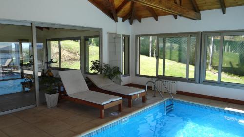 a house with a swimming pool with a chair at Quinta Luna in San Carlos de Bariloche