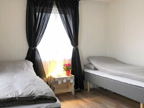 a bedroom with two beds and a window at Holiday home Vevelstad II in Vevelstad
