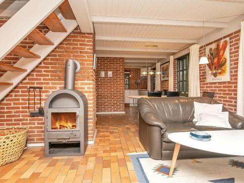 a living room with a brick wall with a fireplace at 6 person holiday home in Ulfborg in Øhuse
