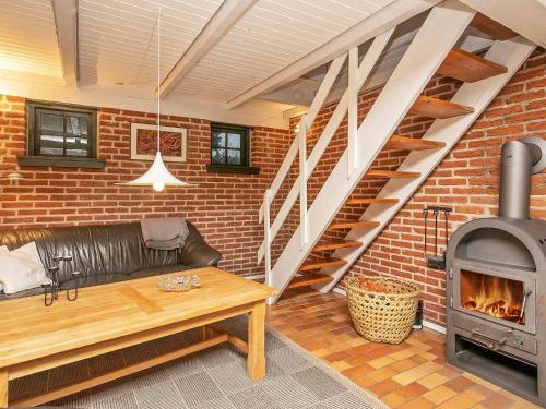 a living room with a couch and a fireplace at 6 person holiday home in Ulfborg in Øhuse