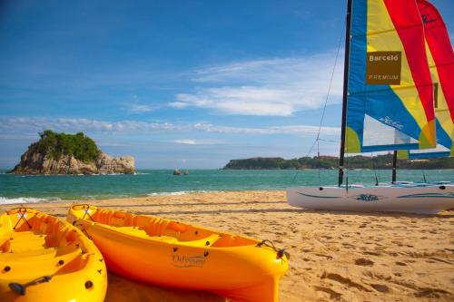 two kayaks and a sail boat on a beach at Barceló Huatulco - All Inclusive in Santa Cruz Huatulco