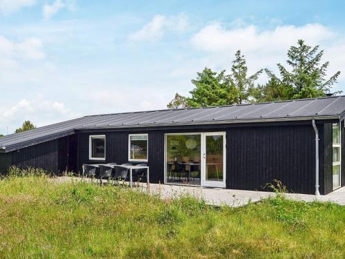una casa negra con techo negro en 6 person holiday home in Fan, en Sønderho