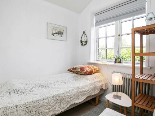 um quarto com uma cama e uma janela em Holiday home Ålbæk XLIX em Ålbæk