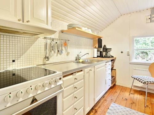 a kitchen with white cabinets and a sink at 4 person holiday home in HALLABRO-By Traum in Svarvaremåla