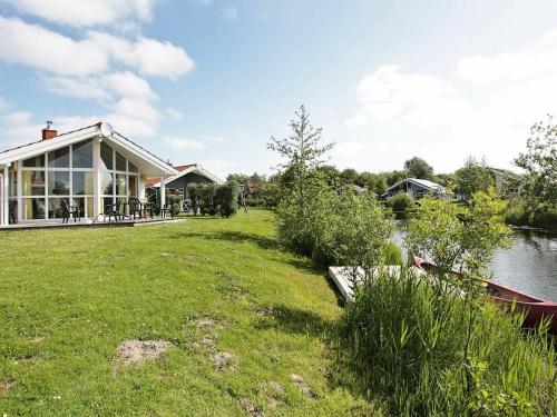 ein Haus mit einem großen Hof neben einem Fluss in der Unterkunft 5 person holiday home in Otterndorf in Otterndorf