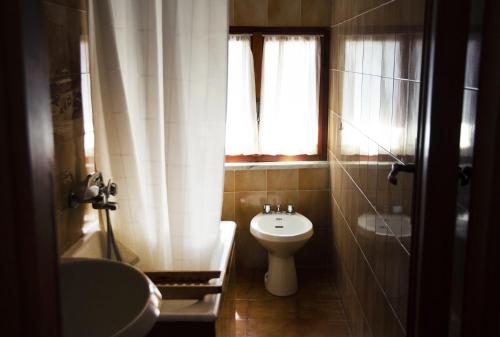 baño con aseo y lavabo y ventana en Nonna Maria, en Moneglia