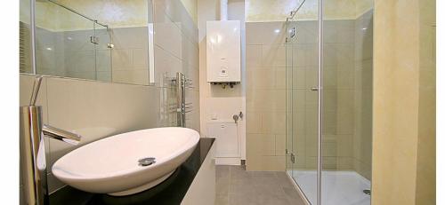 bagno con lavandino e doccia in vetro di Schönbrunn Luxury Apartment a Vienna