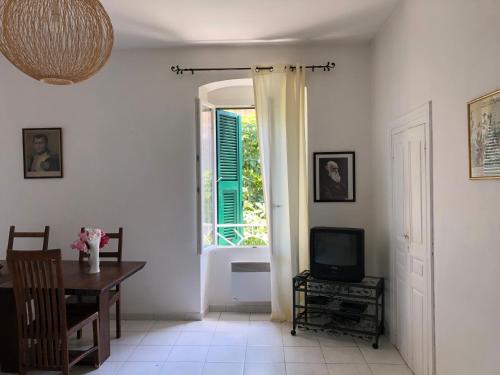a living room with a table and a window at Casa Eugénie l'appartement de tante Madeleine vue sur les montagnes in Venaco