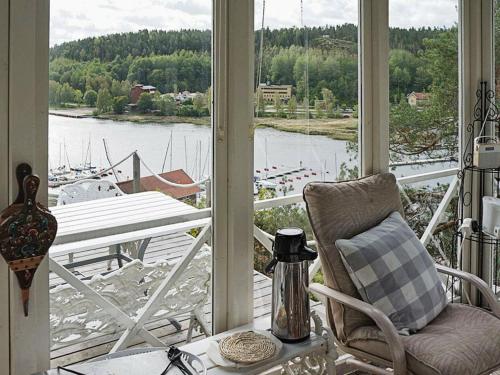 uma varanda com vista para uma marina com uma cadeira e uma mesa em 4 person holiday home in VALDEMARSVIK em Valdemarsvik