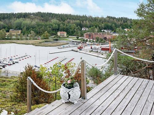 dos personas sentadas en un puente mirando un puerto deportivo en 4 person holiday home in VALDEMARSVIK en Valdemarsvik