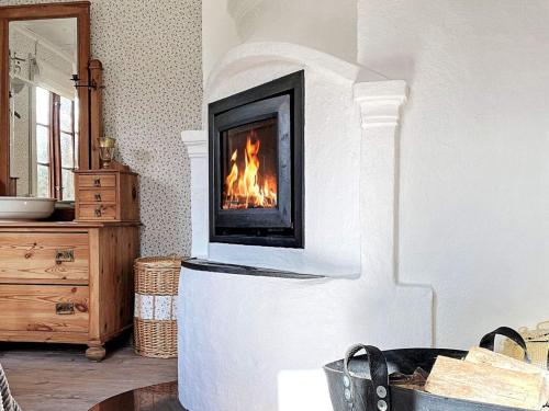 a fireplace in a living room with a fire in it at 10 person holiday home in SKILLINGARYD in Skillingaryd