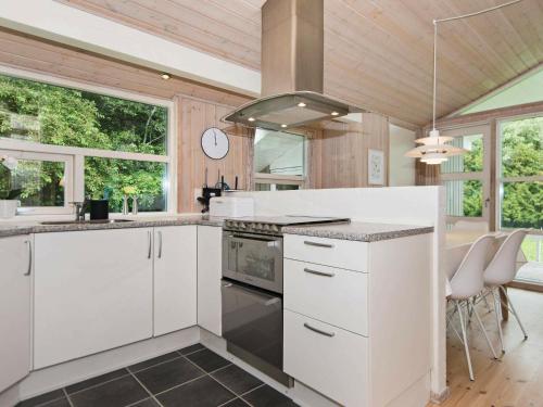 a kitchen with white cabinets and a stove top oven at 6 person holiday home in Silkeborg in Silkeborg