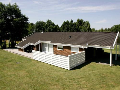 a house with a roof on top of a yard at 8 person holiday home in Aakirkeby in Vester Sømarken