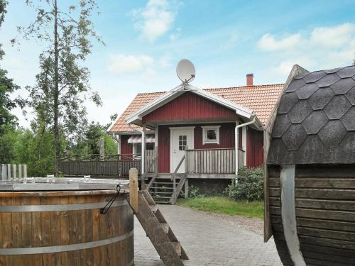een rood-wit huis met een houten hek bij 6 person holiday home in LJUNG in Alboga